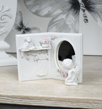 Un petit ange se regarde dans le miroir de la gard