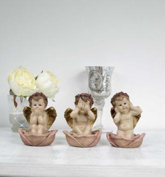 Trois petits anges de la sagesse assis dans des ro